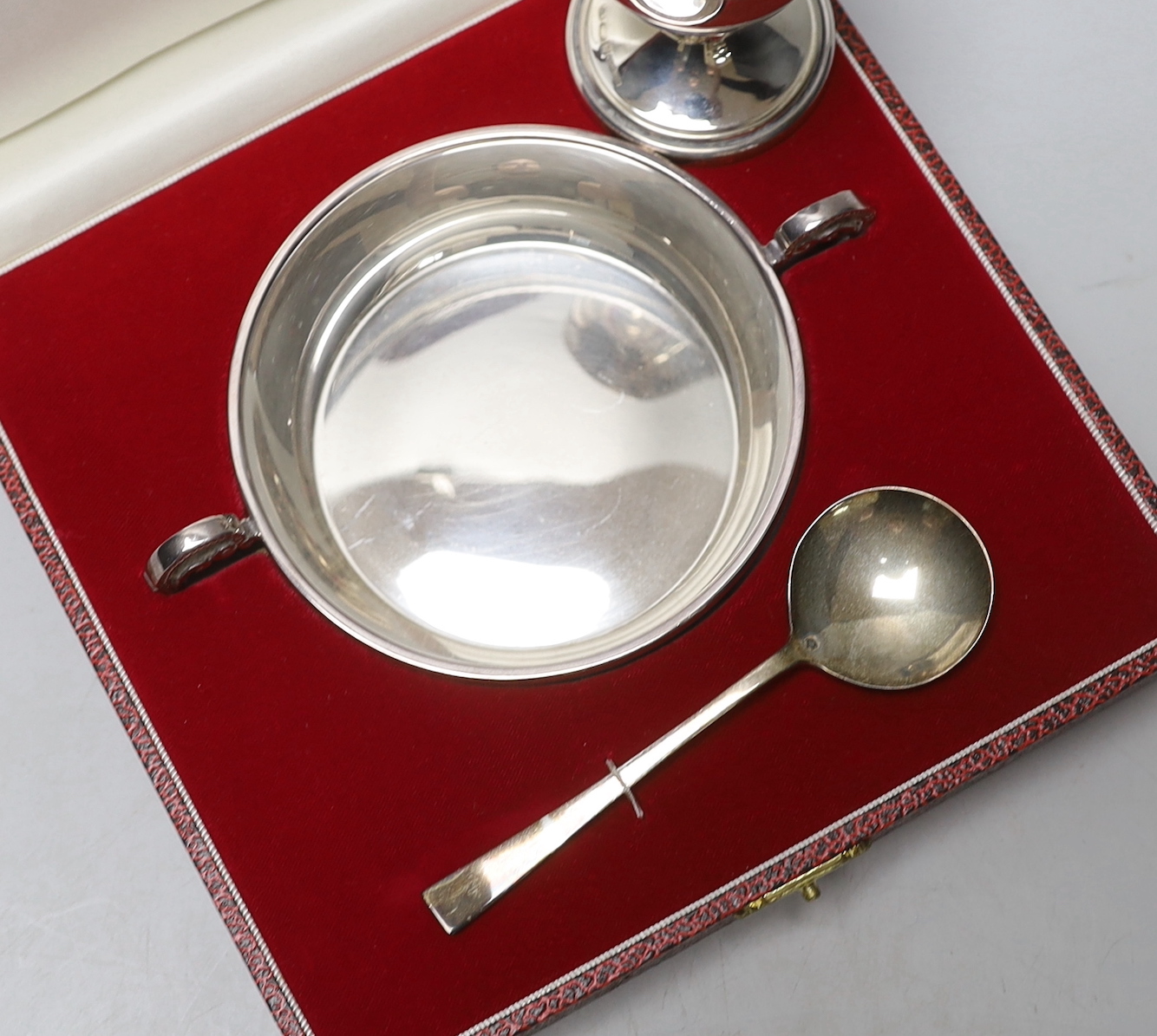 A cased modern silver christening porringer and spoon, Francis Howard Ltd, Sheffield, 1989 and an Italian 925 egg cup.